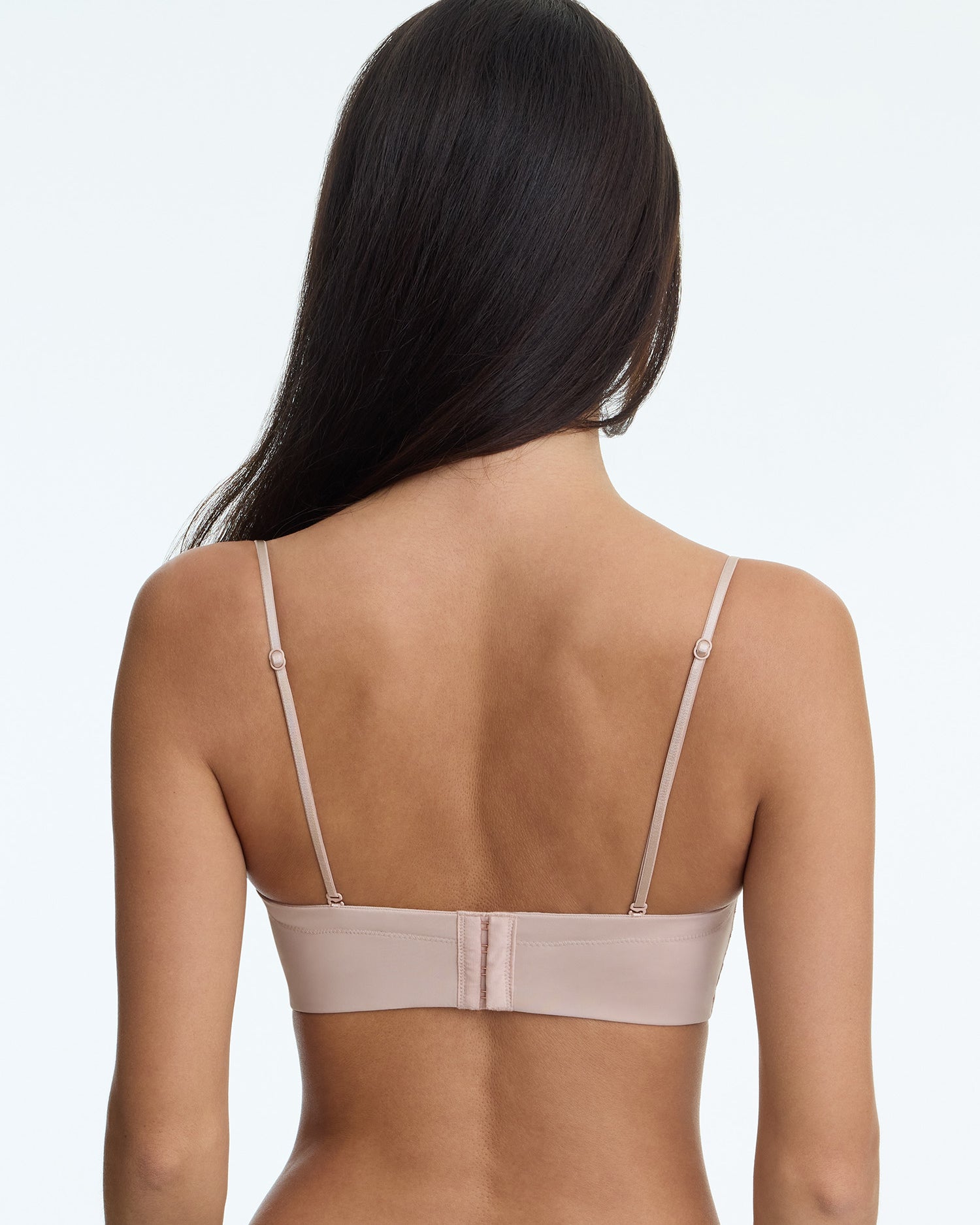 Woman wearing a beige bra on a white background