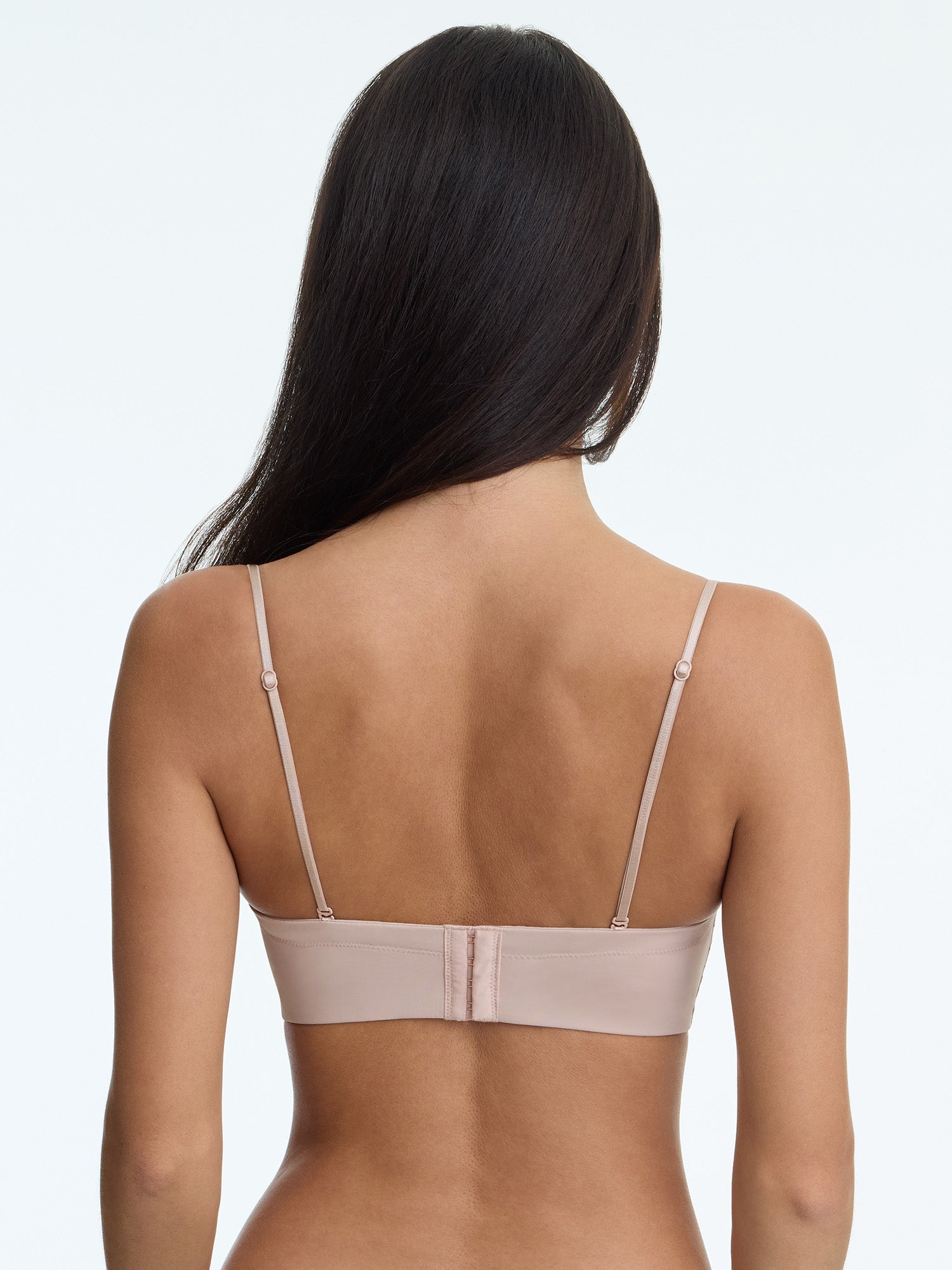 Woman wearing a beige bra on a white background