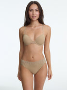 Woman wearing a beige bra and panties set on a white background