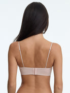 Woman wearing a beige bra on a white background