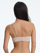 Woman wearing a beige bra on a white background